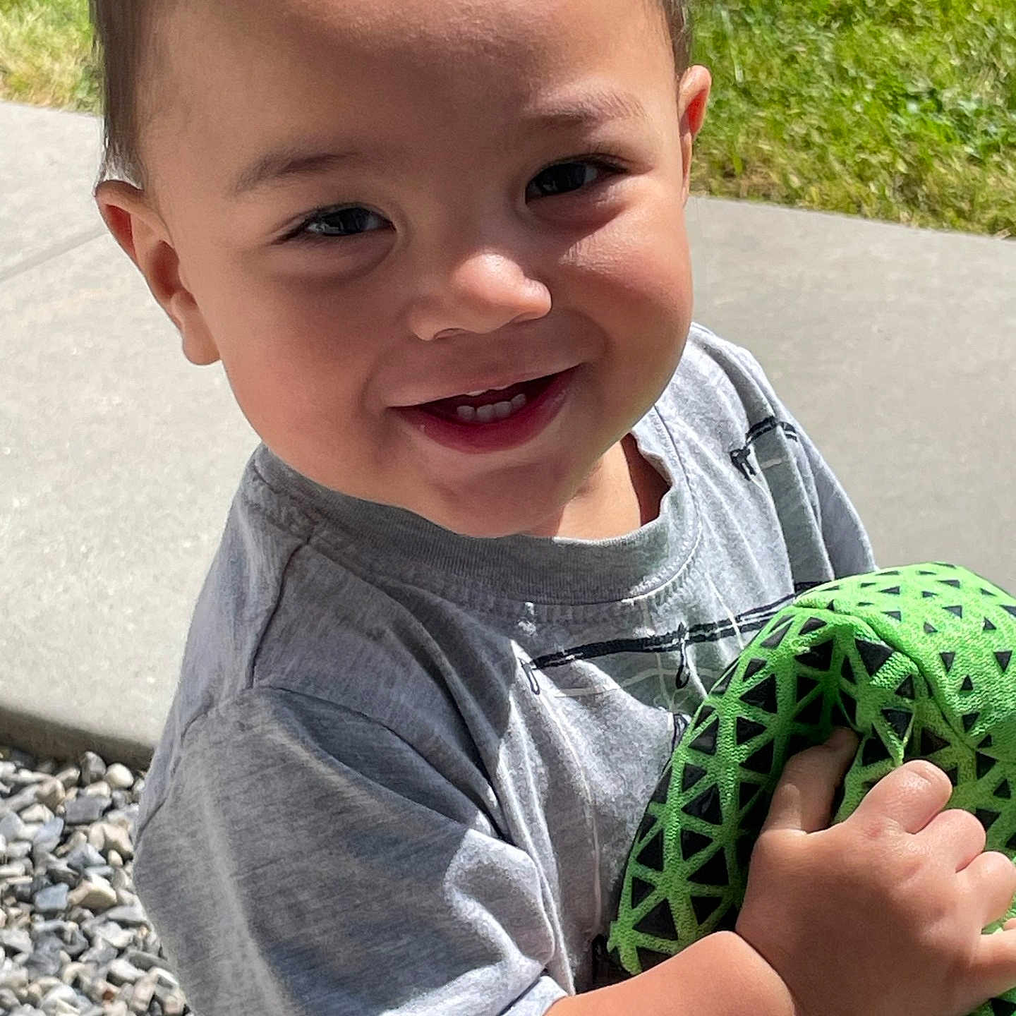 Noah is registered to the contest to win money with this photo: baby, ball, bodypart, clothing, face, football, grass, happy, head, pants, person, photography, plant, portrait, rock, smile, soccer, soccerball, sport, t_shirt