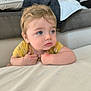 Elio a rejoint le concours — aidez-le/la à gagner de superbes lots ! baby, blue_eyes, blonde_hair, child, curious, face, indoor, leaning, looking_away, portrait, soft_surface, toddler, yellow_clothing, blanket, pillow, home, cozy, expression, skin, young_child