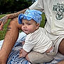 Smokey joined the competition — help win amazing prizes! baby, child, blue_cap, polka_dot, tattoo, adult, outdoor, grass, blanket, pattern, drool, clothing, person, shorts, tshirt, sitting, expression, park, daylight, casual