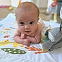 baby, infant, child, play_mat, toy, indoor, curious, lying_down, arms, head, face, eyes, expression, soft_toy, colorful, blanket, floor, cute, young, portrait