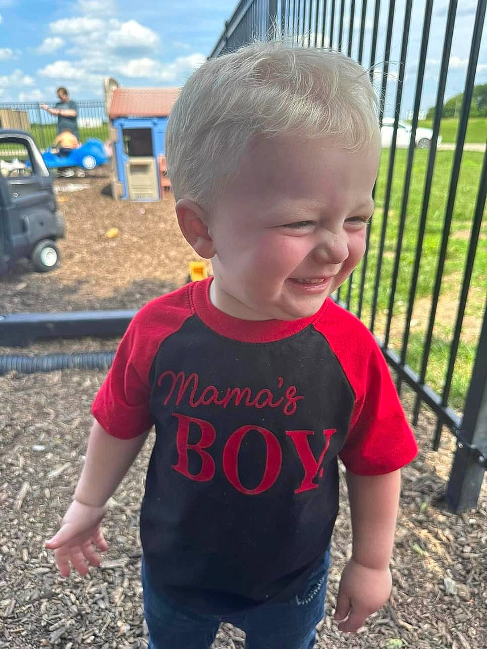 Levi is registered to the contest to win money with this photo: baby_toddler_clothing, blue, chin, city, cloud, electric_blue, fence, fun, grass, happy, joy, leisure, person, product, skin, sky, sleeve, smile, standing, t_shirt