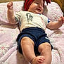 Katia is registered to the contest to win money with this photo: baby, infant, smiling, red_headband, bow, white_tshirt, nike_logo, navy_shorts, blanket, pink_blanket, floral_pattern, foot, hand, skin, indoor, carpet, cute, happy, person, child