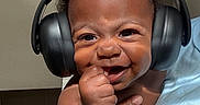 Roman is registered to the contest to win money with this photo: adult, arms, baby, blue_shirt, child, close_up, eyes, face, hair, hand, happy, headphones, holding, indoor, infant, joyful, person, photography, portrait, smiling