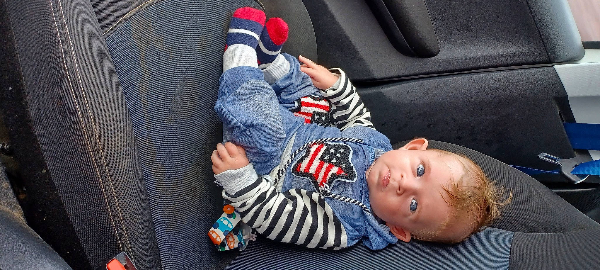 Noé participe au concours pour gagner de l'argent avec cette photo : baby, baby_in_car_seat, baby_products, baby_toddler_clothing, car_seat, child, comfort, cool, denim, elbow, facial_expression, finger, fun, gesture, leg, mouth, orange, person, steering_wheel, thumb