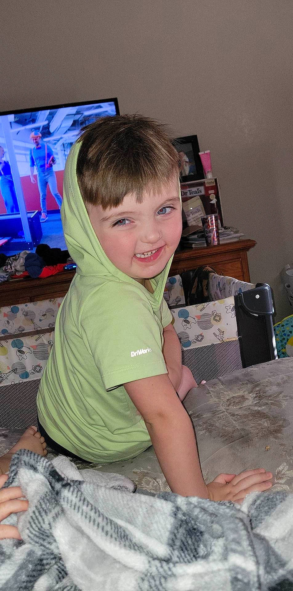 John is registered to the contest to win money with this photo: audio_equipment, child, comfort, computer_keyboard, flooring, fun, home_appliance, joy, lap, led_backlit_lcd_display, person, play, room, sitting, sleeve, smile, t_shirt, television, television_set, thigh