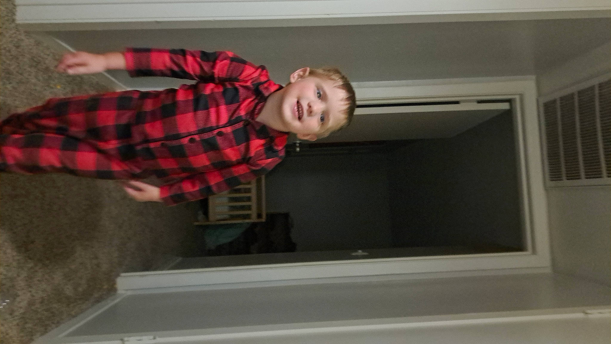 Braxton is registered to the contest to win money with this photo: ceiling, collar, comfort, elbow, flooring, fun, hardwood, joy, pattern, person, plaid, room, sitting, sleeve, standing, t_shirt, tartan, toddler, window, wood