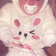 Yvana participe au concours pour gagner de l'argent avec cette photo : baby, infant, pacifier, headband, bow, hooded_suit, fuzzy_onesie, plush_texture, beaded_pacifier_clip, blanket, close_up, face, cheeks, sleepwear, pink, white, cute, indoor, time_stamp, phone_ui