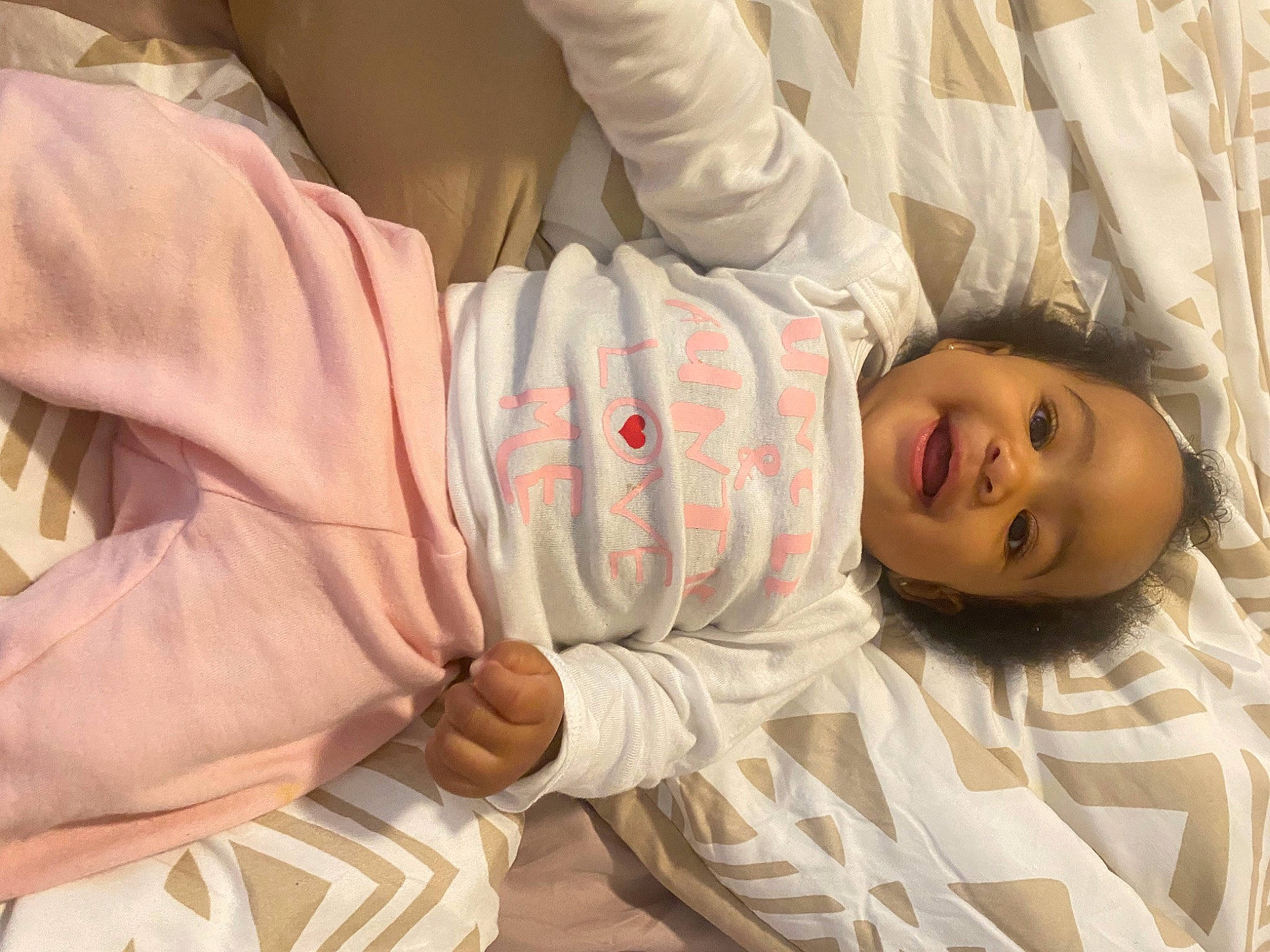 Aaliyah joined the competition — help win amazing prizes! baby, baby_products, baby_toddler_clothing, bed, bedding, child, comfort, face, finger, gesture, happy, linens, pattern, person, room, skin, sleeve, smile, textile, thumb