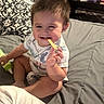 Julian is registered to the contest to win money with this photo: toddler, child, smiling, bed, pillow, blanket, indoor, person, cute, happy, baby, clothing, sitting, toy, hand, face, hair, room, furniture, playful