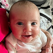 Emery is registered to the contest to win money with this photo: baby, child, closeup, cute, eyes, fabric, face, hand, happy, holding, human, indoors, infant, manicure, onesie, person, portrait, skin, smiling, soft