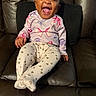 baby, child, laughing, smiling, sitting, indoor, couch, leather, clothing, leggings, pattern, butterfly, heart, happy, person, infant, cute, joyful, toddler, portrait