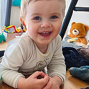 Auguste a rejoint le concours — aidez-le/la à gagner de superbes lots ! baby, blanket, child, clothing, cozy, cute, expression, face, floor, hands, happy, indoor, person, playful, portrait, smiling, teddy_bear, toddler, toy, wooden_floor