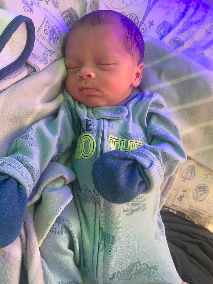 Miki is registered to the contest to win money with this photo: baby, baby_toddler_clothing, cheek, child, comfort, cool, eye, face, gesture, happy, head, iris, linens, nose, person, pink, purple, skin, sleeve, toddler