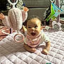 Eliana joined the competition — help win amazing prizes! baby, child, play_mat, toy, plush_toy, hanging_toy, dog, cage, carpet, smiling, indoor, person, curly_hair, bib, happy, cute, infant, face, floor, home
