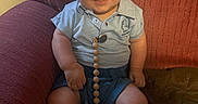Baylor joined the competition — help win amazing prizes! armchair, baby, blue_shirt, blue_shorts, child, clothing, cute, expression, face, furniture, happy, home, indoors, infant, pacifier, person, relaxed, seat, sitting, smiling