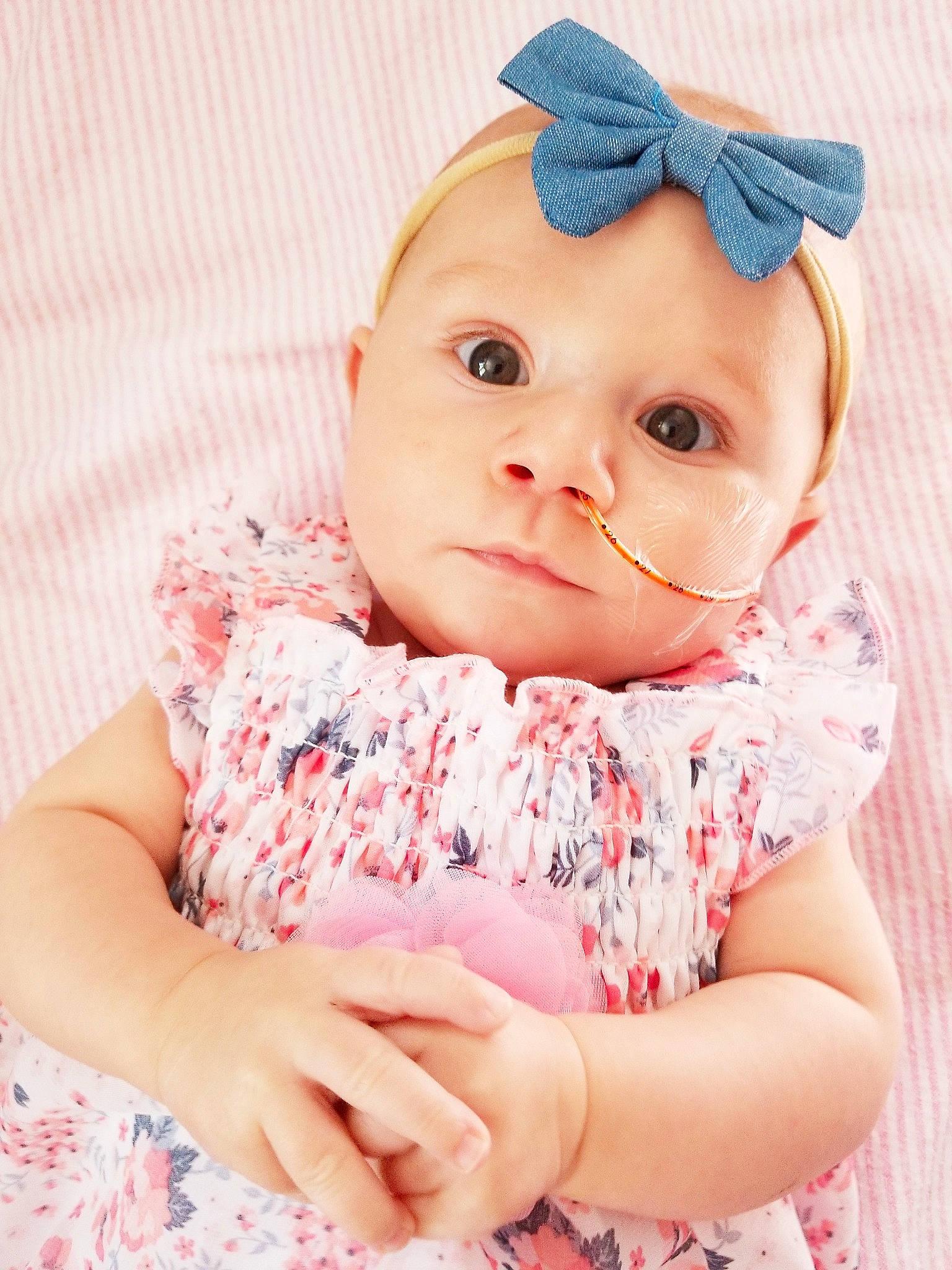 Teagen is registered to the contest to win money with this photo: baby, baby_products, baby_toddler_clothing, cheek, child, dress, ear, eye, hair_accessory, hand, head, headband, headgear, lip, outerwear, pattern, person, pink, product, skin