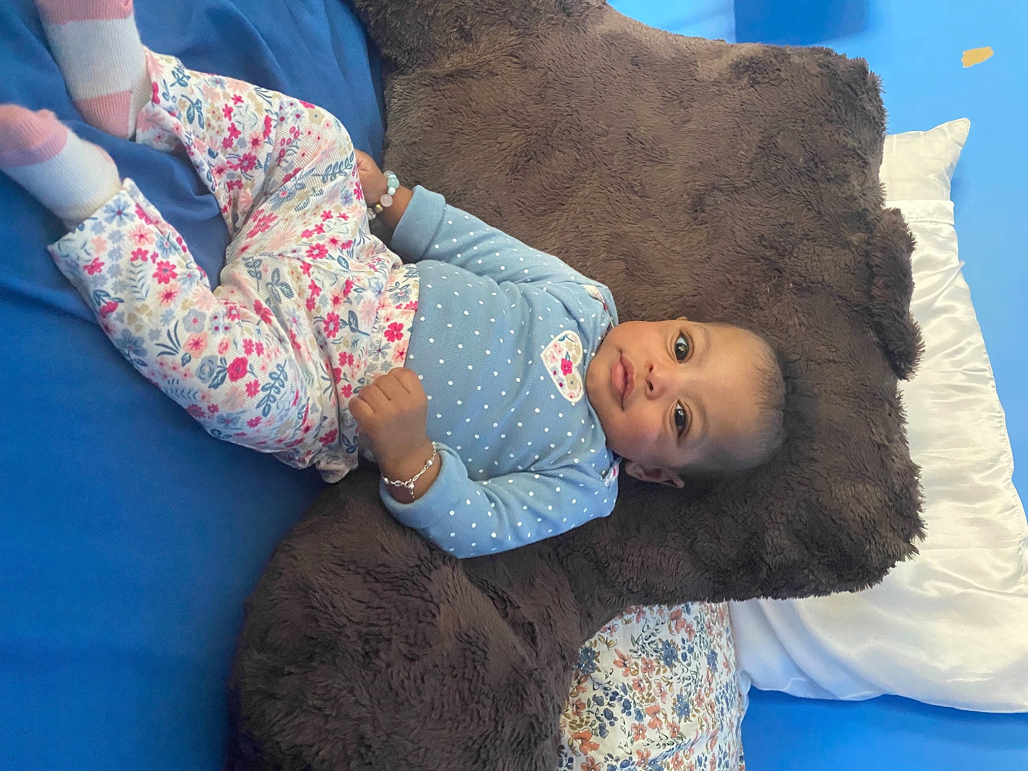 Noavé is registered to the contest to win money with this photo: baby, baby_toddler_clothing, beauty, blue, child, comfort, eye, face, gesture, head, human_body, leisure, linens, organ, person, product, sitting, skin, sleeve, textile