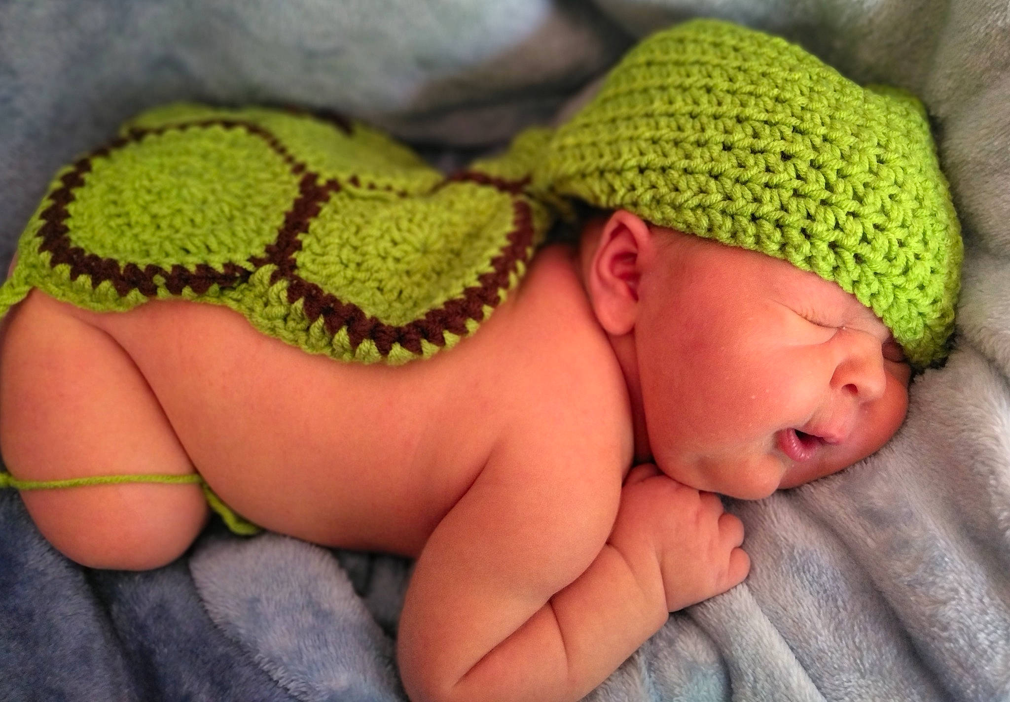 Robert is registered to the contest to win money with this photo: adaptation, baby, baby_sleeping, baby_toddler_clothing, cap, comfort, finger, grass, hand, headgear, headwear, leaf, mammal, mouth, nail, neck, organism, person, skin, textile