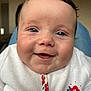baby, smile, face, infant, clothing, white_outfit, red_flowers, blue_flowers, closeup, happy, child, young, cute, skin, head, person, portrait, indoors, eyes, expression