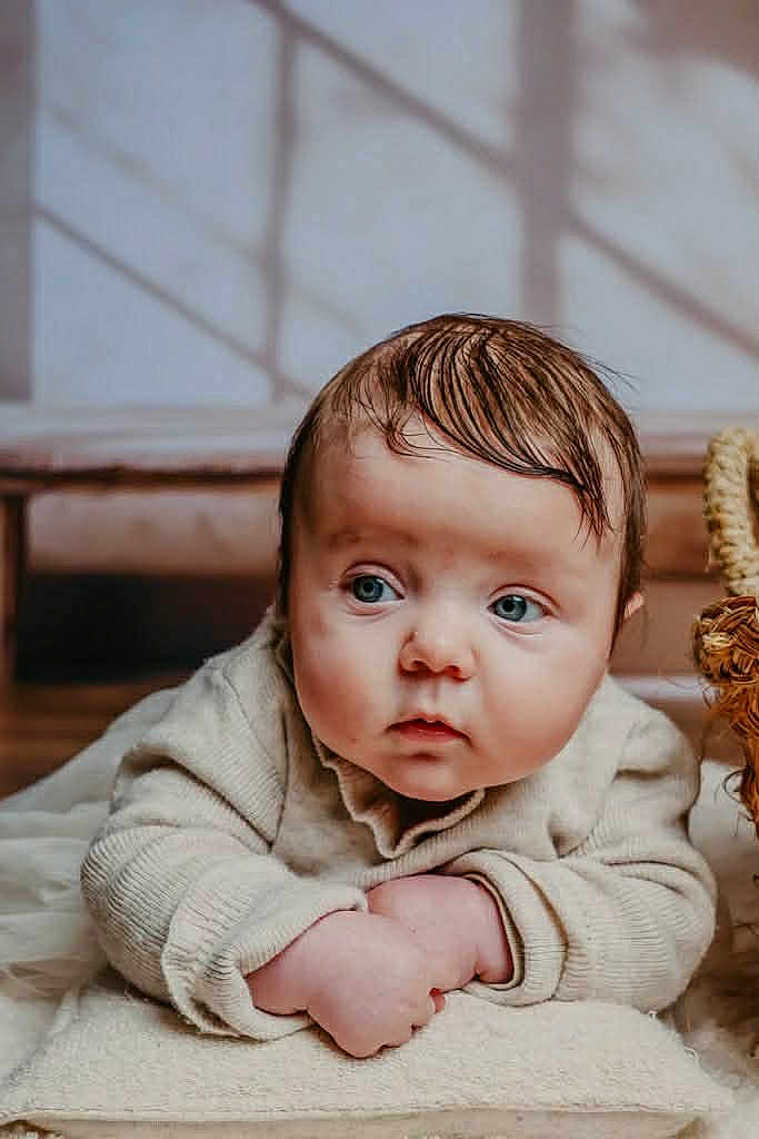 Stella a rejoint le concours — aidez-le/la à gagner de superbes lots ! baby, infant, child, blue_eyes, wet_hair, blanket, cream_color, soft_texture, indoors, natural_light, curious_expression, close_up, crawling_position, young_child, face, person, portrait, warm_tones, cozy, cute