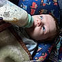 Daniel is registered to the contest to win money with this photo: baby, bottle, feeding, blue_eyes, blanket, pillow, pattern, vehicles, close_up, infant, child, cute, soft, lying_down, hand, milk, indoors, portrait, young, comfort
