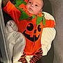 Maylo a rejoint le concours — aidez-le/la à gagner de superbes lots ! baby, infant, pumpkin_costume, orange_clothing, striped_leggings, pacifier, bassinet, crib, sleeping_area, baby_clothes, cute, holiday_costume, toddler, child, lying_down, face, head, blanket, green_leaves, indoors
