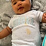 Daïanna a rejoint le concours — aidez-le/la à gagner de superbes lots ! baby, infant, headband, bow, onesie, clothing, blanket, fabric, smile, face, child, cute, lying, textile, stain, skin, person, indoors, comfort, happy