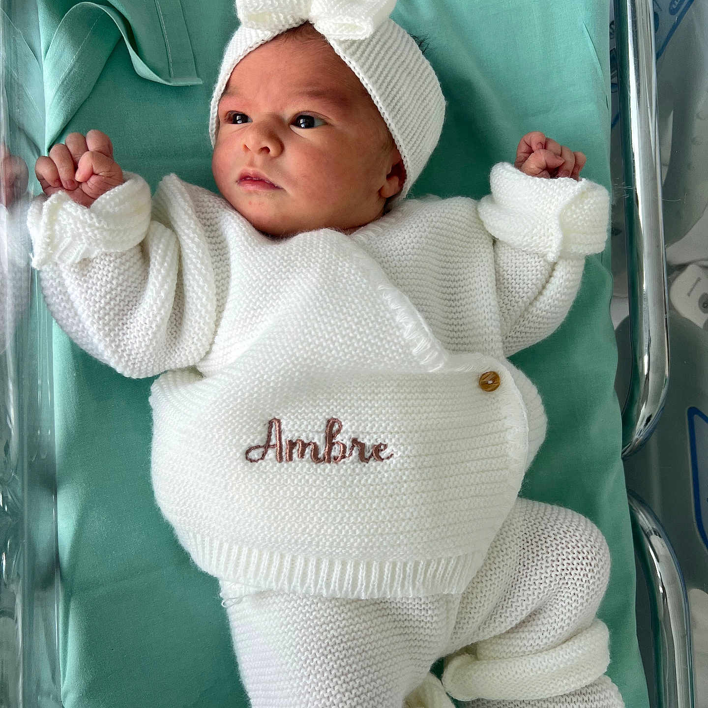 Ambre participe au concours pour gagner de l'argent avec cette photo : baby, newborn, infant, knitted_clothing, white_outfit, headband, bow, crib, hospital, blanket, lying_down, cute, small_hands, tiny_feet, peaceful, curious, portrait, indoors, child, person