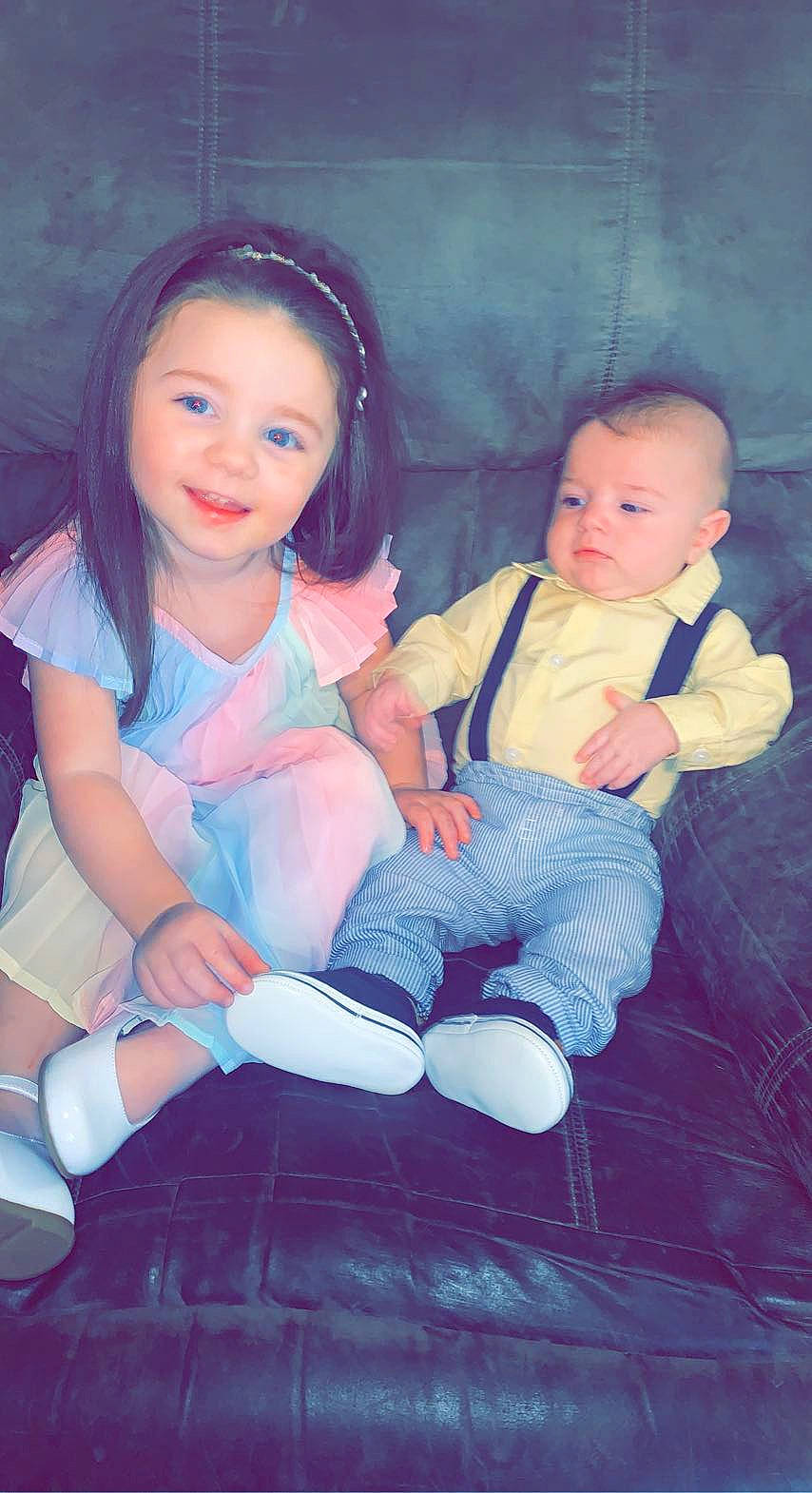 Adeline is registered to the contest to win money with this photo: baby, baby_toddler_clothing, cheek, dress, eye, face, finger, flash_photography, hair, happy, head, headwear, human_body, iris, joy, lap, person, pink, purple, skin