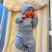 Ilyan a rejoint le concours — aidez-le/la à gagner de superbes lots ! newborn, baby, sleeping, blue_clothing, hat, blanket, bassinet, hospital, infant, peaceful, cute, soft_texture, cozy, child, person, portrait, resting, small_hands, footed_pajamas, indoors