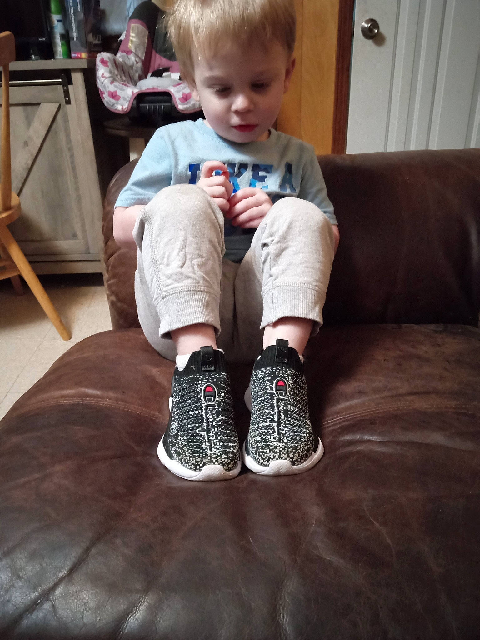 Isaac is registered to the contest to win money with this photo: baby_toddler_clothing, comfort, cool, elbow, electric_blue, flooring, foot, human_leg, joint, knee, lap, leg, person, sleeve, sock, sportswear, standing, t_shirt, thigh, toddler