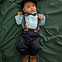 Henry is registered to the contest to win money with this photo: baby, bow_tie, child, clothing, cute, expression, face, fashion, footwear, green_background, hat, indoor, infant, lying_down, pants, person, portrait, shirt, shoes, suspenders