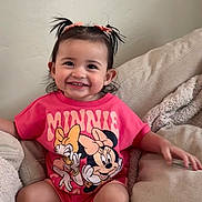 Alexus is registered to the contest to win money with this photo: child, toddler, smiling, sitting, pink_shirt, minnie_mouse, pigtails, couch, cozy, blanket, indoors, cute, happy, person, face, hair_bow, white_socks, casual, comfortable, portrait