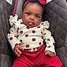 Kyomi is registered to the contest to win money with this photo: baby, child, car_seat, polka_dot, red, white, headband, tongue_out, cute, infant, clothing, seatbelt, warning_label, padded, portrait, indoor, person, smile, hands, expression