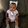 baby, child, girl, headband, bow, hello_kitty, shirt, socks, chair, quilted, seated, curious, indoor, cute, infant, portrait, one_person, clothing, expression, comfortable