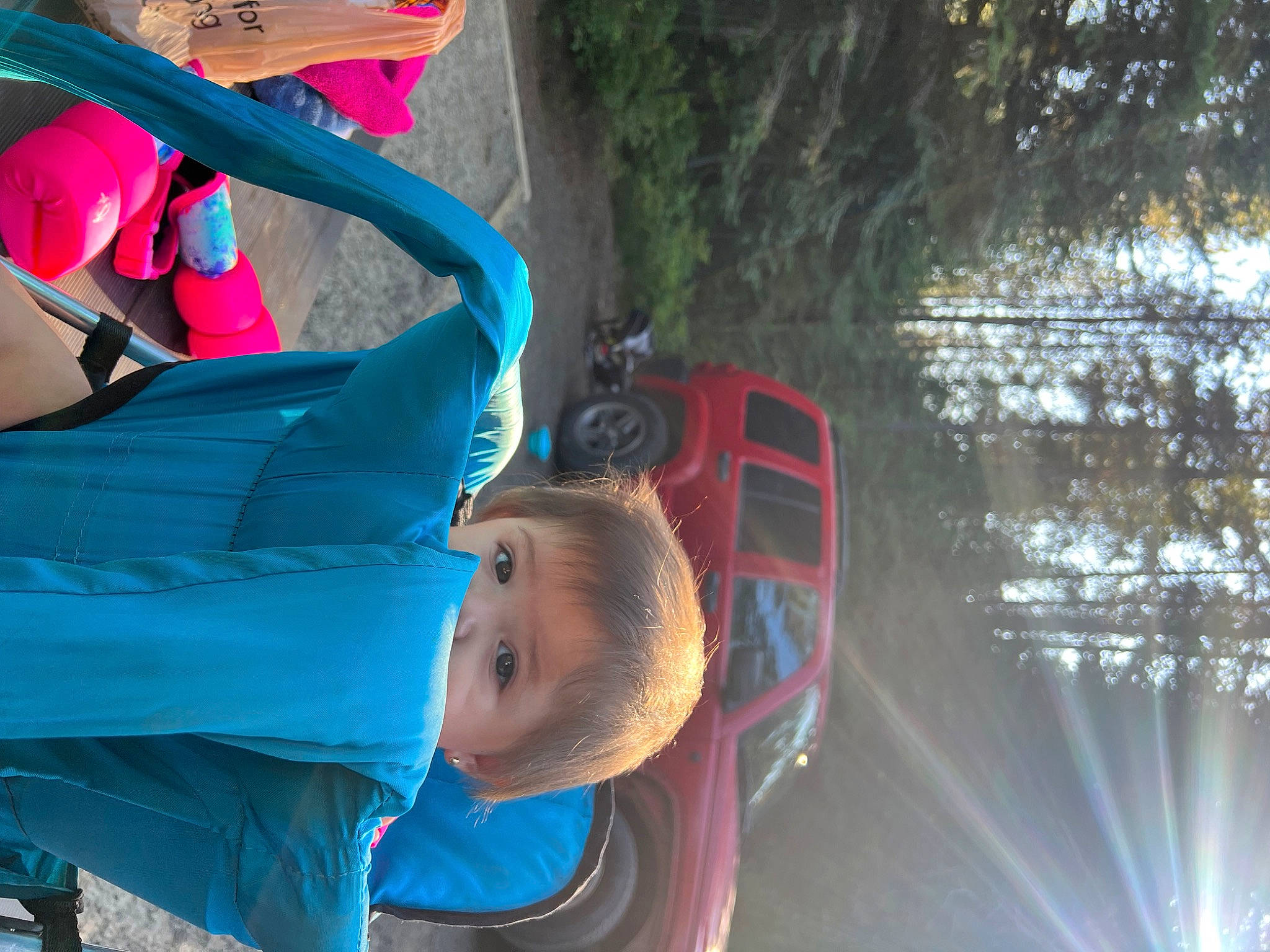 Ella is registered to the contest to win money with this photo: auto_part, automotive_exterior, automotive_wheel_system, child, electric_blue, fun, leisure, people, person, plant, recreation, snapshot, tire, toddler, tree, vacation, vehicle, water, wheel, winter