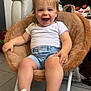 chair, child, cushion, cute, denim_shorts, floor_tiles, footwear, furniture, happy, home, indoor, person, plush_chair, seated, short_hair, smiling, sneakers, toddler, toy_car, white_tshirt