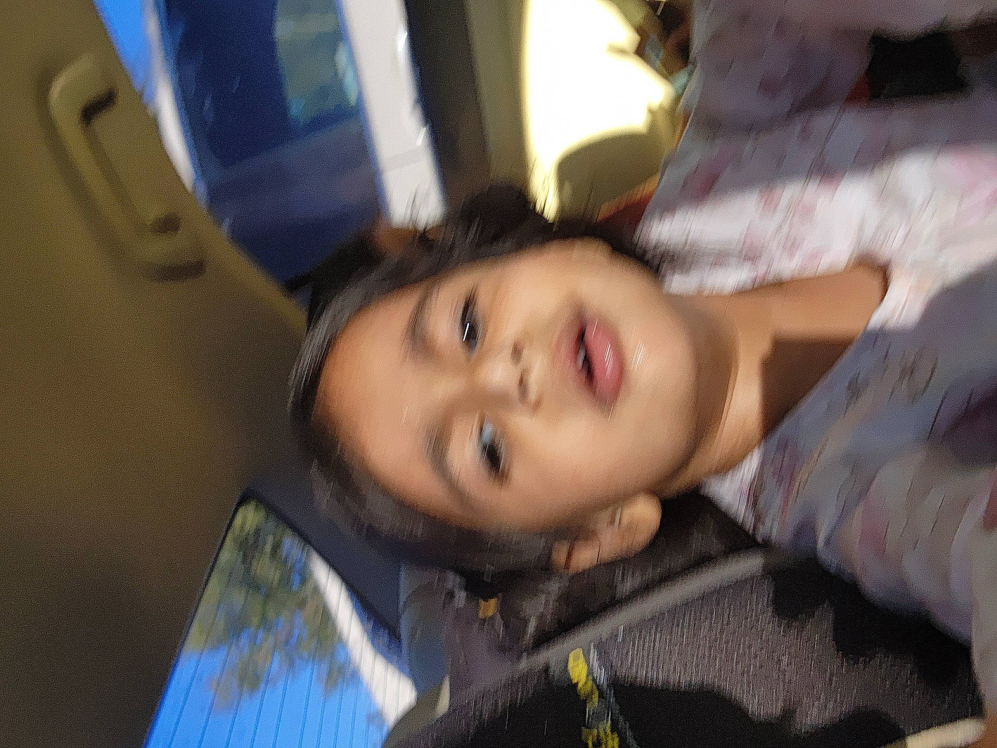 Anaya is registered to the contest to win money with this photo: black_hair, cheek, child, eyebrow, eyelash, forehead, fun, happy, iris, jaw, mouth, nose, person, sitting, smile, tree, vehicle_door, window, wood