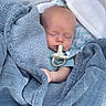 John is registered to the contest to win money with this photo: baby, blanket, pacifier, sleeping, child, infant, blue_blanket, cushion, outdoor, baby_seat, peaceful, resting, clothing, head, person, young_child, soft_texture, comfort, nap, closeup