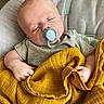 John joined the competition — help win amazing prizes! baby, pacifier, blanket, sleeping, infant, onesie, cushion, cozy, child, resting, yellow_blanket, hand, face, head, soft_texture, indoor, comfort, peaceful, closeup, portrait