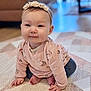 Ava is registered to the contest to win money with this photo: baby, child, infant, girl, headband, pink_sweater, crawling, carpet, patterned_rug, indoor, smiling, cute, person, home, floor, hands, feet, soft_lighting, portrait, cozy
