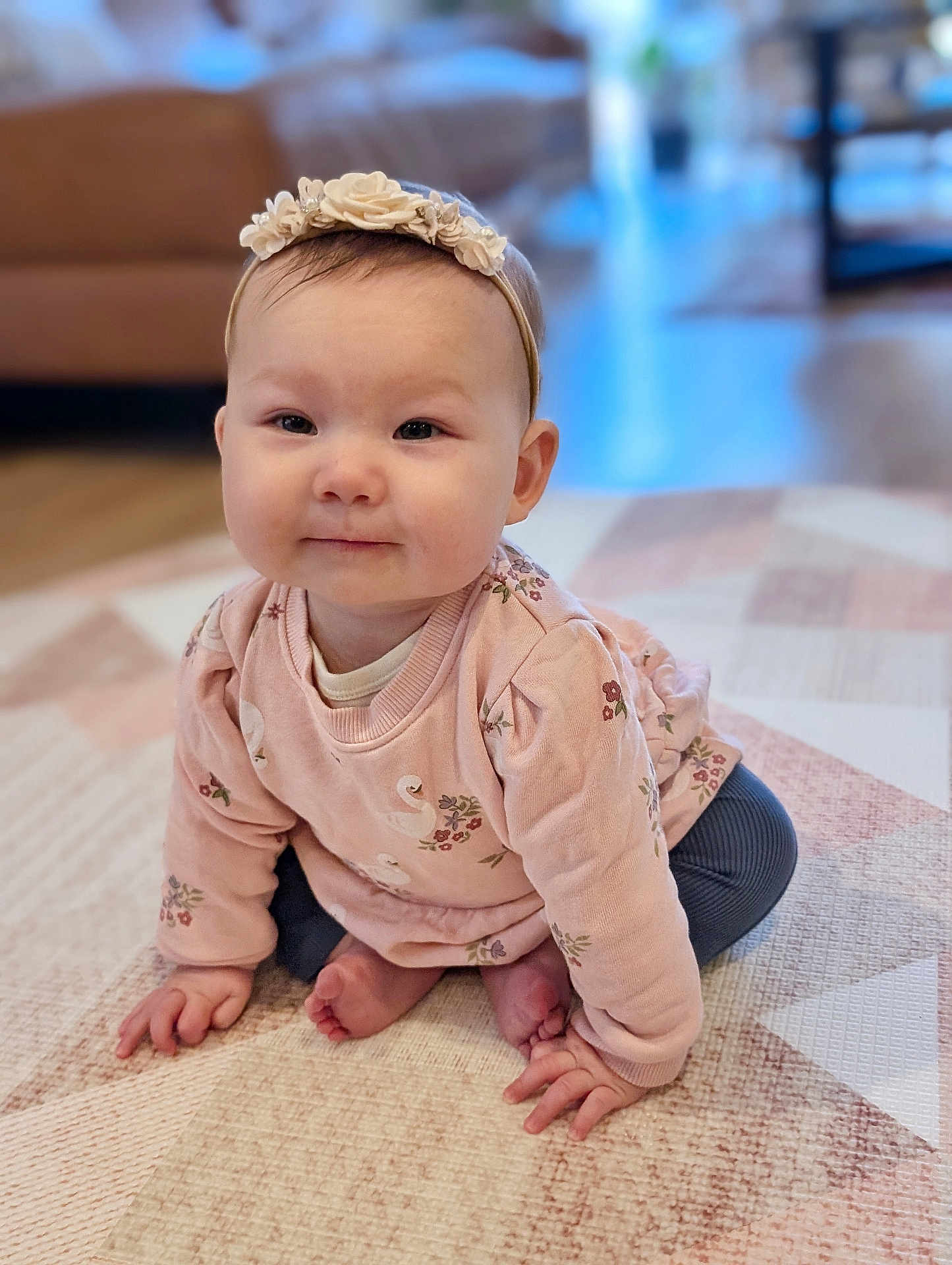 Ava is registered to the contest to win money with this photo: baby, child, infant, girl, headband, pink_sweater, crawling, carpet, patterned_rug, indoor, smiling, cute, person, home, floor, hands, feet, soft_lighting, portrait, cozy