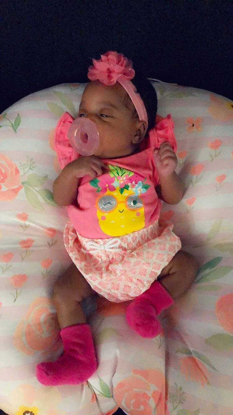 Chanel is registered to the contest to win money with this photo: baby, baby_toddler_clothing, cheek, child, comfort, eye, face, facial_expression, finger, happy, head, headgear, lip, mouth, person, pink, skin, sleeve, sweetness, toddler