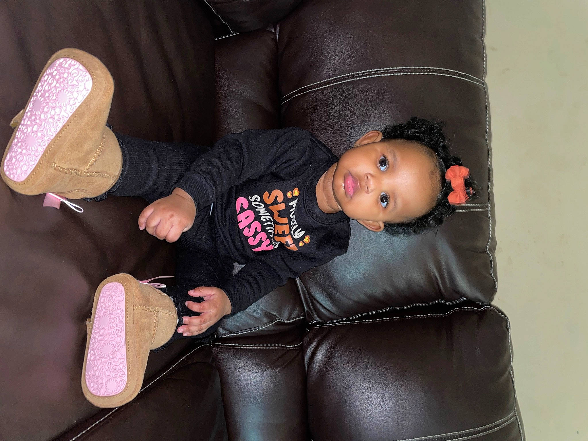 Kailani is registered to the contest to win money with this photo: baby, baby_toddler_clothing, black, boot, car_seat, carmine, child, comfort, face, human_leg, knee, lap, latex, person, sitting, sleeve, sock, textile, thigh, toddler