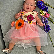 Thaïs participe au concours pour gagner de l'argent avec cette photo : apparel, baby, child, couch, cute, dress, floral, flowers, footwear, gray, happy, headband, indoors, infant, lying_down, pink, portrait, purple, shoes, smiling