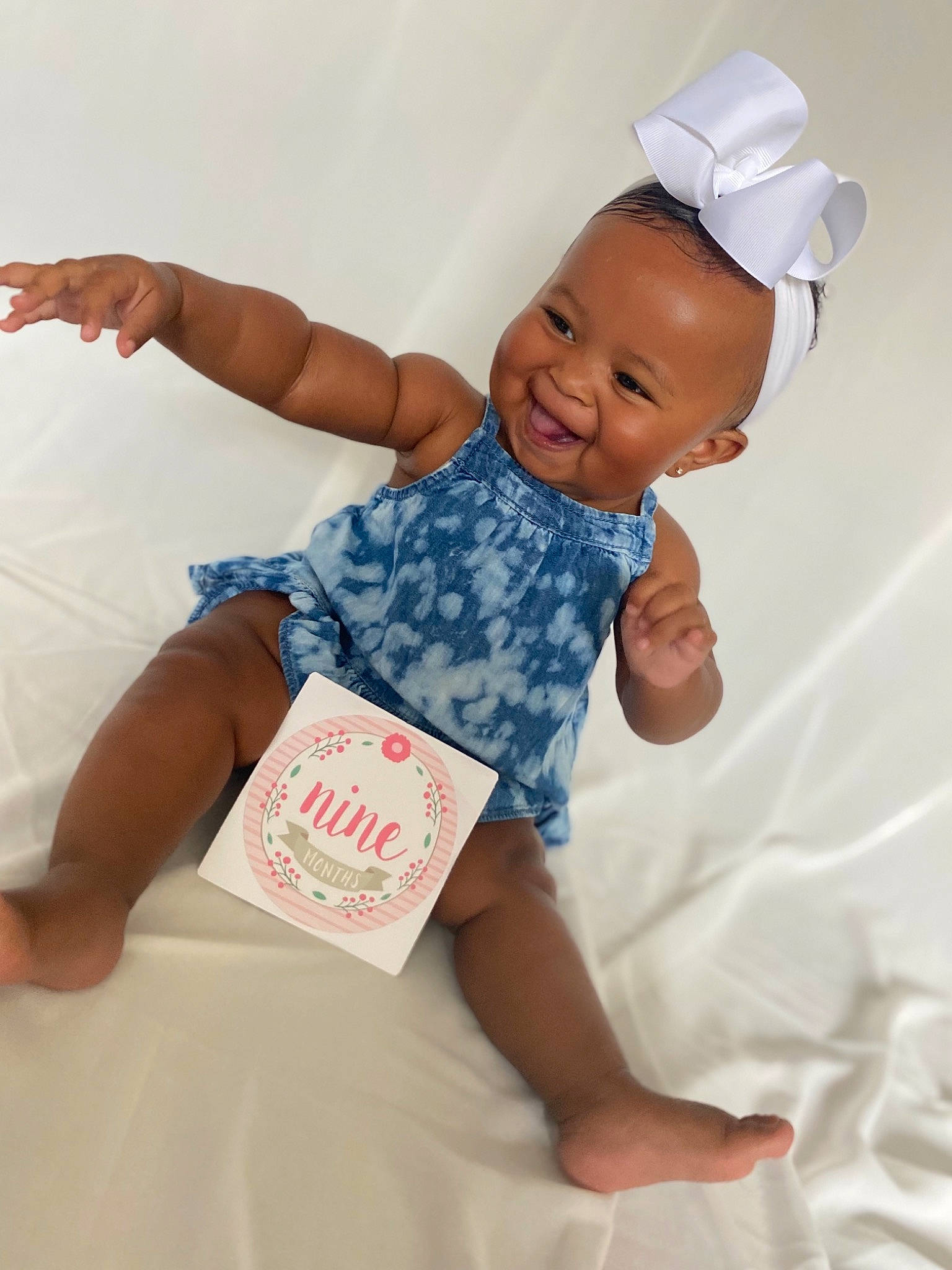 Bria is registered to the contest to win money with this photo: arm, baby, baby_toddler_clothing, cap, child, comfort, elbow, finger, fun, gesture, happy, joy, leg, person, pink, skin, sleeve, smile, t_shirt, textile