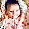 baby, baby_accessory, bib, blanket, blue_eyes, cheeks, closeup, cozy, fabric, gaze, hair, hand, infant, pacifier, plush_toy, portrait, sitting, star_pattern, strawberry_pattern, zipper