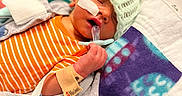 Micah joined the competition — help win amazing prizes! newborn, baby, infant, sleeping, hospital, medical, pacifier, knit_cap, onesie, blanket, crib, bed, face, hand, wristband, tubing, monitor, orange, portrait, indoors