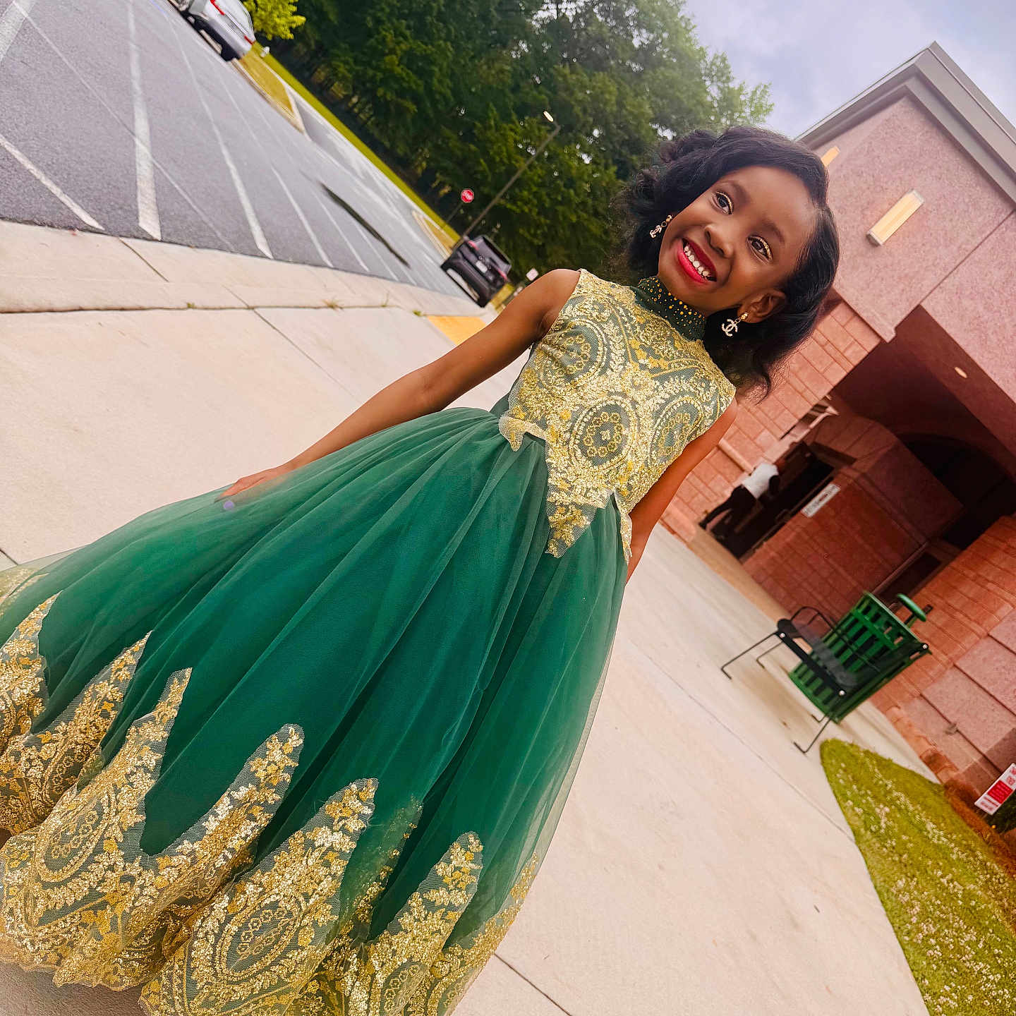 Kali joined the competition — help win amazing prizes! building, child, cloudy_sky, concrete, curly_hair, dress, earrings, fashion, girl, gold_embroidery, grass, green_dress, happy, outdoor, parking_lot, person, posing, sidewalk, smile, tree