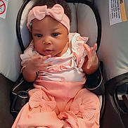 Kehlani joined the competition — help win amazing prizes! baby, infant, child, car_seat, pink_outfit, headband, bow, dress, frills, sitting, portrait, face, smiling, hands, indoor, vehicle, safety_harness, carriage, fashionable, photography